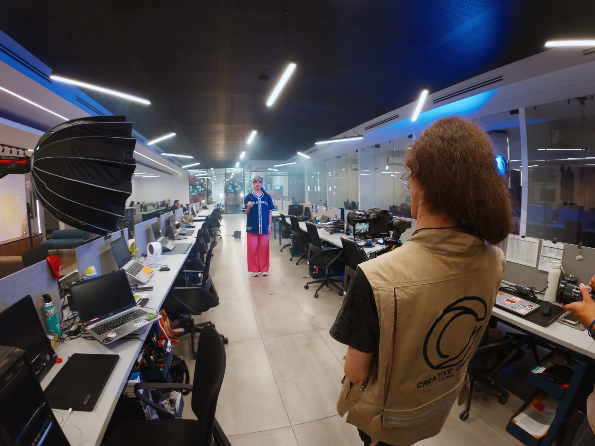 Camarógrafo filmando en una oficina con luz de estudio