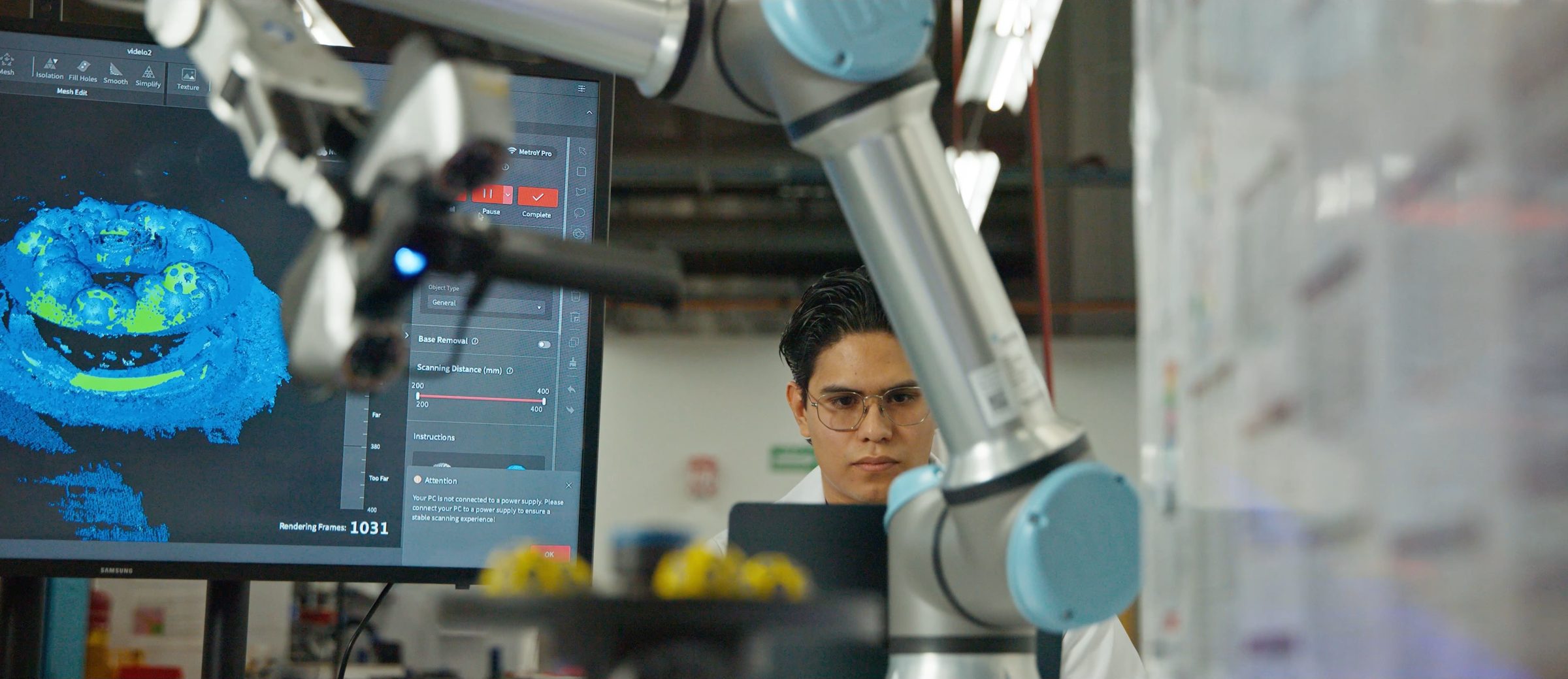 Ingeniero observa un brazo robótico y un escaneo 3D en la planta de Safran