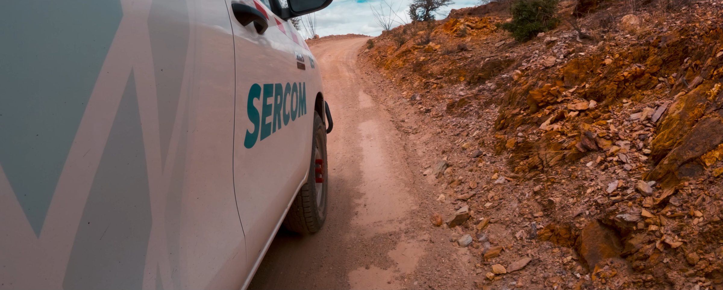 Camioneta de SERCOM avanza por un camino de terracería entre rocas