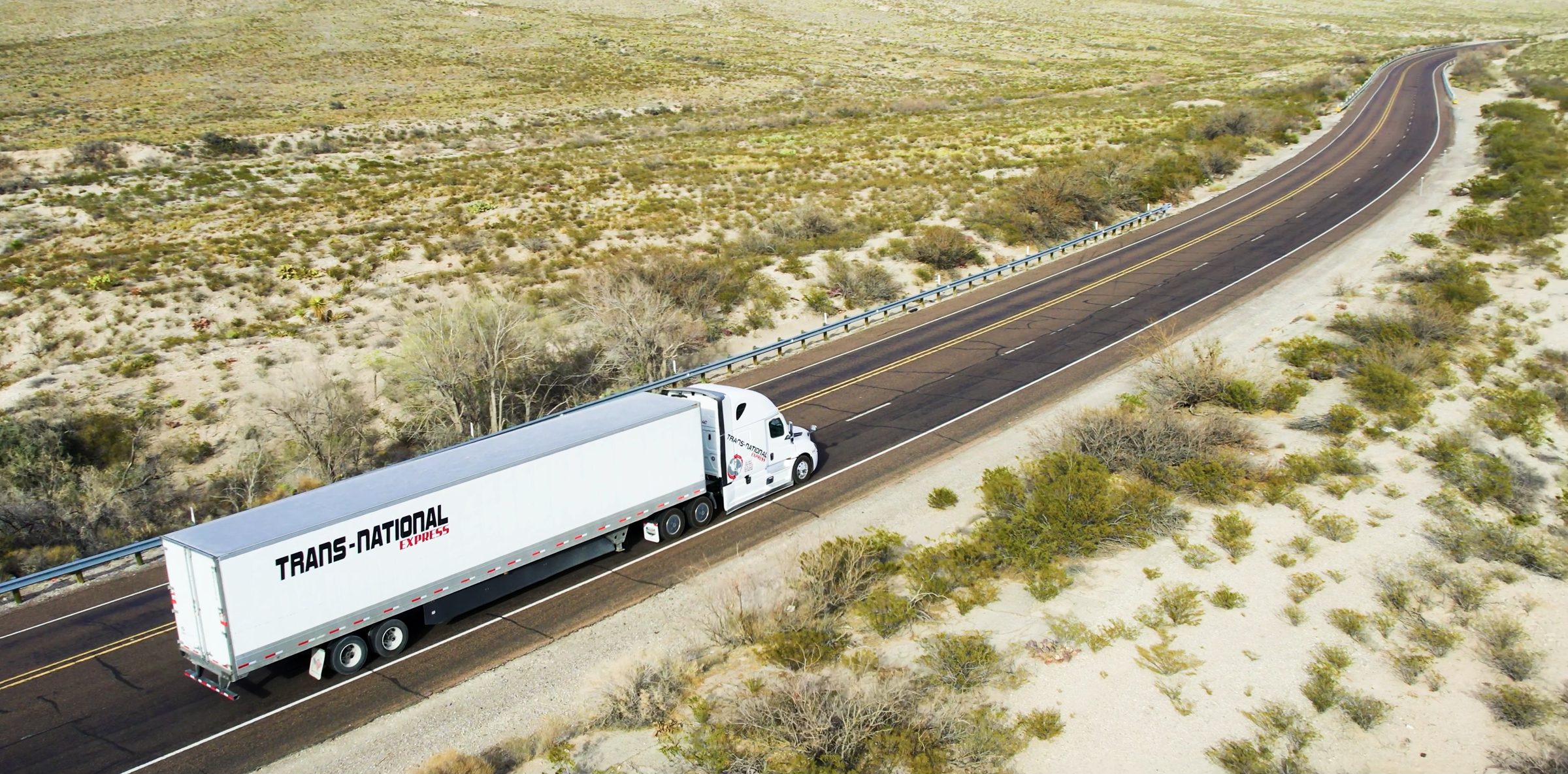 Tractocamión de Transnational Express en una carretera del desierto, vista aérea